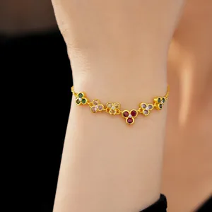 Detailed view of a gold-plated bracelet with colorful zircon flower clusters on a female wrist