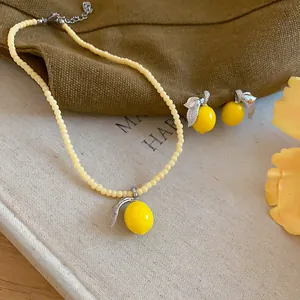 Dettaglio macro della collana di perle gialle al limone e del set di orecchini