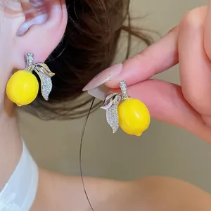 Vista dettagliata di orecchini a forma di limone con foglia in zirconi micro-pave