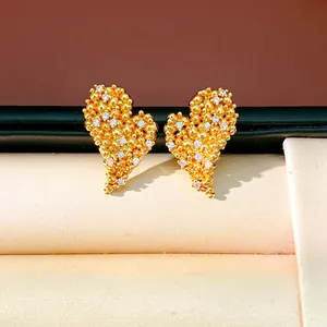 Gros plan sur les puces d'oreilles cœur plaqué or 18 carats avec pierres de zircone.