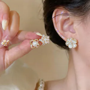 Macro view of French vintage pearl and zircon flower stud earrings on ear