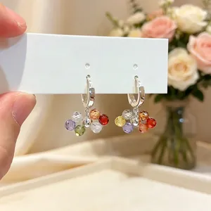 Close-up of colorful glass bead hoop earrings with faceted candy-colored spheres.