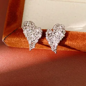 Gros plan de boucles d'oreilles en forme de cœur serties de zircons clairs et étincelants