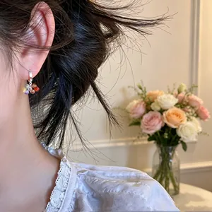 Close-up detail of colorful glass bead cluster earrings on model, sweet candy style jewelry.