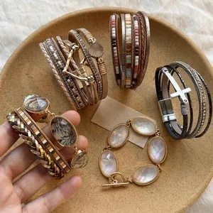 Vista dettagliata di bracciali in pelle multistrato boho con ciondoli a cuore e croce