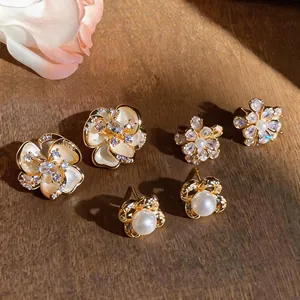 Detailed view of three pairs of vintage French floral pearl and zircon stud earrings.