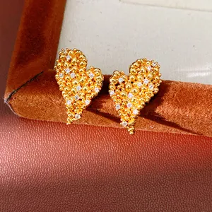 Gros plan de boucles d'oreilles cœur plaquées or 18 carats avec oxydes de zirconium scintillants.
