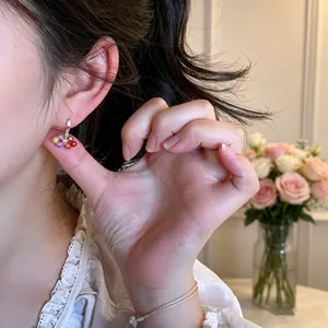 Detailed close-up of colorful glass bead earrings in candy colors worn by a model.