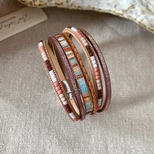 Vista dettagliata di bracciale bohémien multistrato in pelle con perline e chiusura magnetica