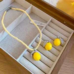 Dettaglio di set collana di perline e orecchini al limone giallo con foglie di zirconi