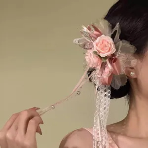 Detailansicht einer süßen rosa Blumen-Haarklammer mit feiner Spitze und Perlen bei einem Model.
