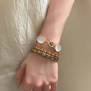 Vista dettagliata di bracciali bohémien multistrato con resina e pelle intrecciata