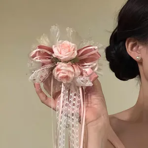 Detaillierte Nahaufnahme der rosa Rosen-Haarklammer mit Spitzenbändern und zarten Perlen