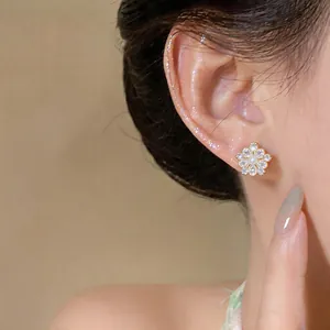 Detailed view of elegant French vintage flower stud earring with pearl and zircons on ear