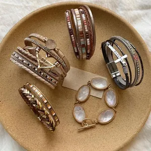 Vista dettagliata di bracciali boho multistrato in pelle con ciondoli a cuore e pietra