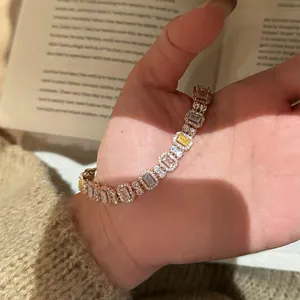 Detailansicht eines bunten Zirkon-Armbands, gehalten in der Hand über einem Buch