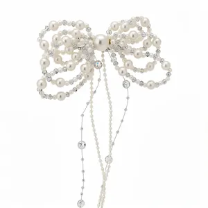 Elegant pearl bow hair clip with sparkling crystal tassels on white background