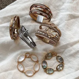 Assortimento di braccialetti multi-strato in pelle boho con cuori e pietre in resina.