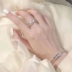 Elegante Detailaufnahme eines 14-karätig vergoldeten Zirkon-Kreuzrings an einer Hand