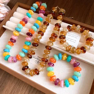 Detailed view of colorful marbled acrylic bead necklaces and bracelets in a tray