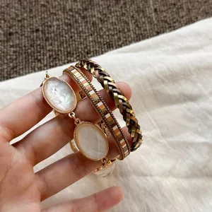 Vista dettagliata di bracciali bohémien in pelle multistrato con pietre bianche di resina