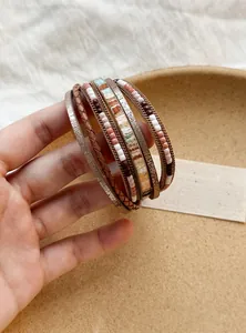 Primo piano di un bracciale multistrato in pelle in stile bohémien con perline colorate