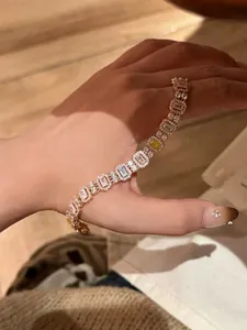 Nahaufnahme eines eleganten Rotgold-Armbands mit quadratischen farbigen Zirkonia.