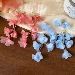 Close-up of elegant handmade chiffon flower tassel earrings in pink and light blue colors