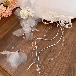 Close-up of pearl bow hair clip with elegant tassels and fabric flower details