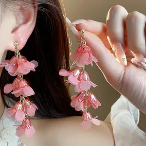Detailed view of pink chiffon flower tassel earrings worn by model for elegant style