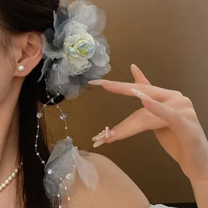 Close-up of elegant grey fabric flower hair clip with long pearl tassels