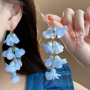 Close-up of light blue chiffon flower tassel earrings with iridescent acrylic details