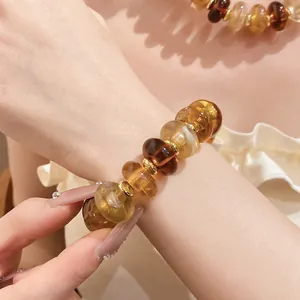 Close-up of amber acrylic marbled bead bracelet on wrist with matching necklace