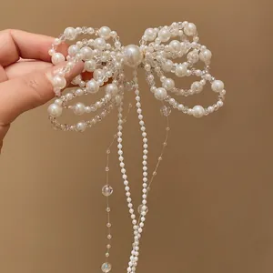 Close-up of elegant pearl bow hair clip with long tassel detail for women