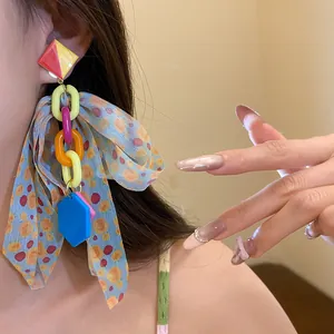 Detailed view of colorful bow tassel earrings with acrylic links and polka dots