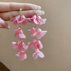 Macro view of pink chiffon flower tassel earrings with iridescent acrylic caps
