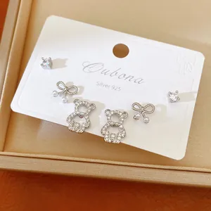 Set of 3 pairs of silver stud earrings featuring teddy bear, bow, and zircon designs