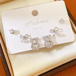 Close-up view of sparkling zircon bear and bow stud earrings set in a premium jewelry box