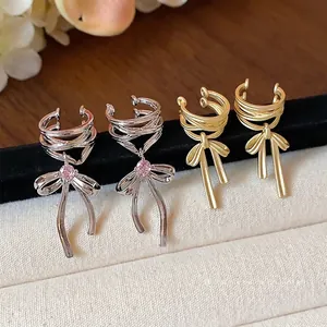 Elegant bow ear cuffs with pink stones and matte gold finish design for non-pierced ears.