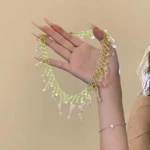 Gros plan d'un ras-de-cou floral fait main en perles vert tilleul et rose de style Mori.