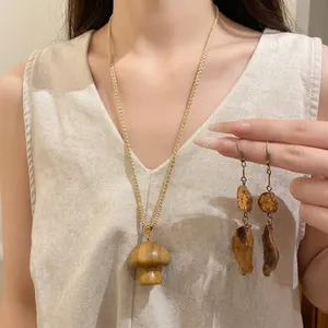 Handcrafted wooden mushroom pendant necklace and drop earrings with woven cotton cord.