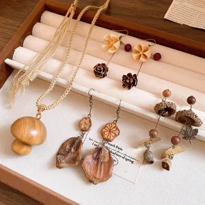 Detail view of handmade wooden mushroom pendant necklace and vintage nature style earrings