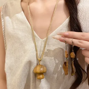 Detailed view of handmade wooden mushroom pendant and matching retro wood earrings.