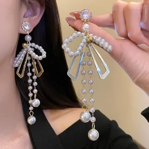 Detailed shot of bow pearl tassel earrings with crystal studs in vintage style