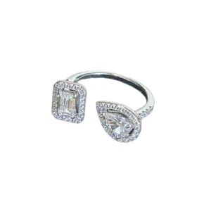 Minimalist silver open ring featuring an emerald-cut and a pear-cut zircon stone.