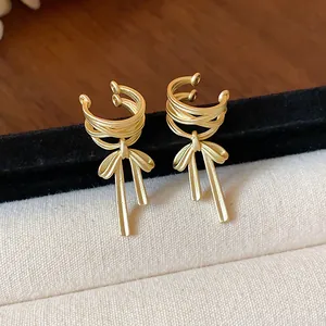 Elegant matte gold bow-knot ear cuff earrings with stylish ribbon tassel detail.