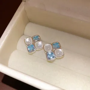 Vintage silver stud earrings with light blue zircon and white resin in jewelry box