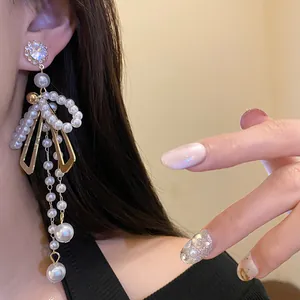 Detailed view of elegant French vintage bowknot pearl tassel earrings with rhinestones.
