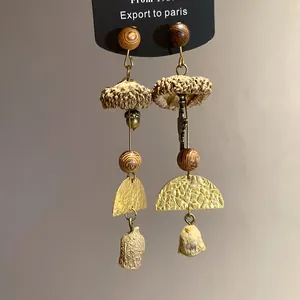 Detailed close-up of handmade wooden mushroom drop earrings with retro textures