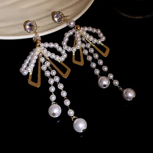 Detailed view of elegant pearl bow tassel earrings with sparkling crystal studs.